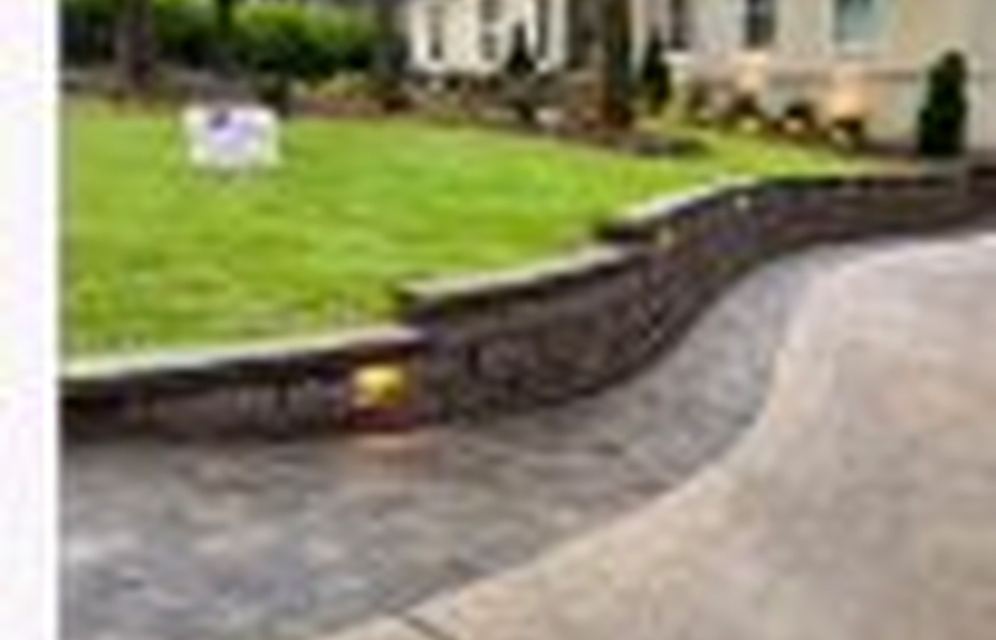 Stone retaining wall and paver driveway
