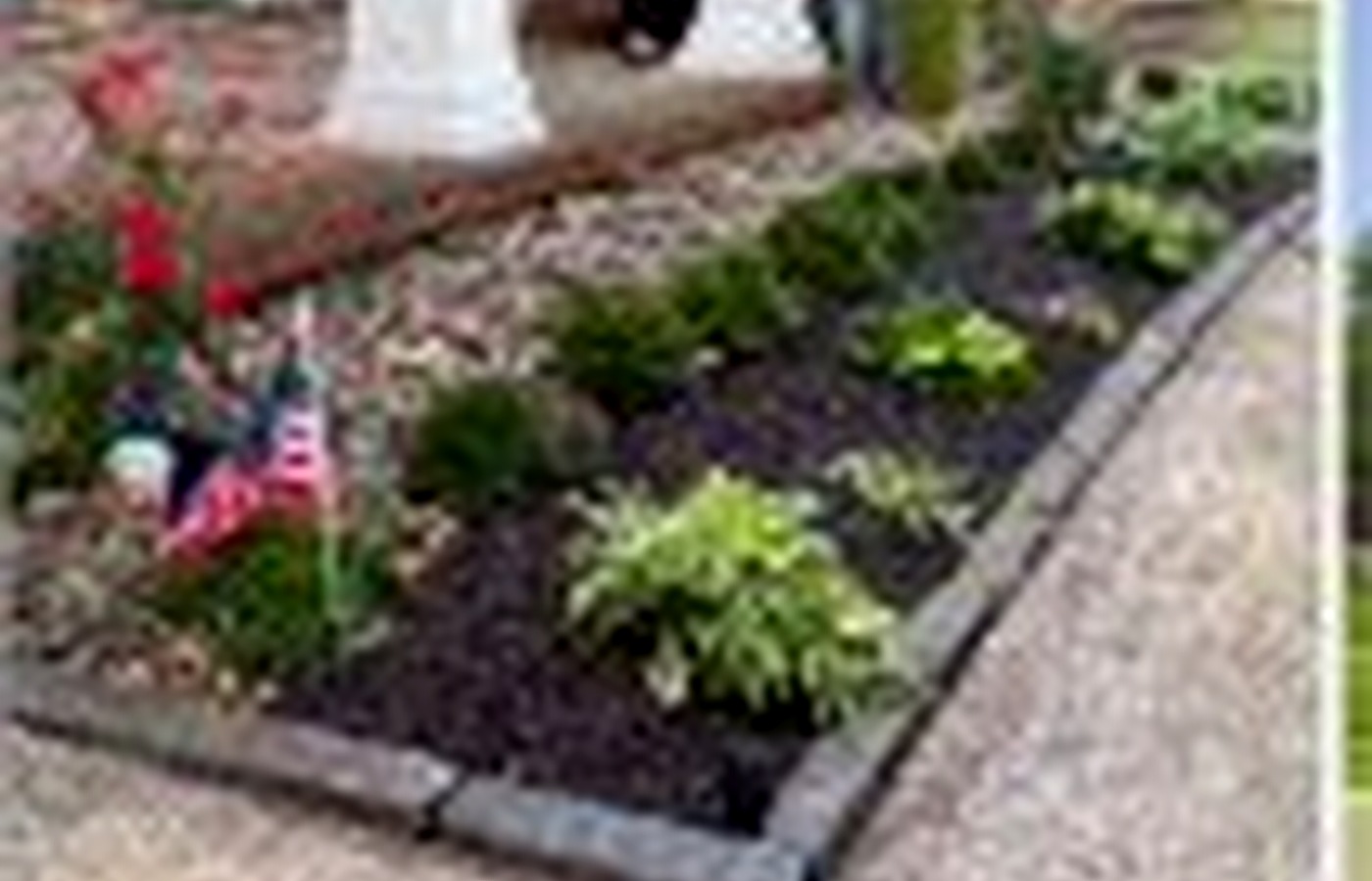 Garden bed with plants and mulch along walkway