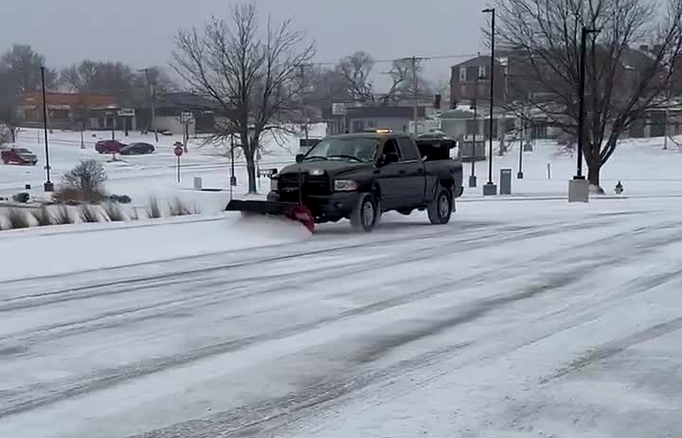 Snowplow clearing a snowy lot for snow and ice management
